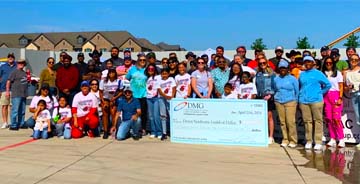 Dallas Mechanical employees posing with a fundraising check at the Down Syndrome Guild of Dallas event