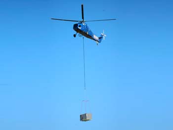 Helicopter lifting a large HVAC unit